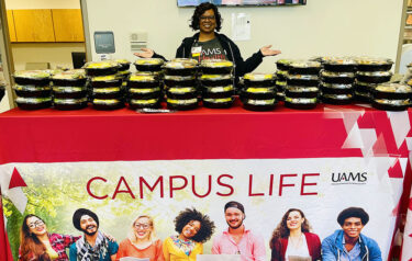  Kristy Caldwell, DrPH, student services director, poses with the student box lunches handed out as part of Lunch at the Student Center.