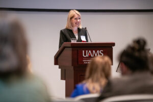 Woman giving a presentation at a lectern.