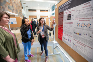 Faculty members looking at research poster